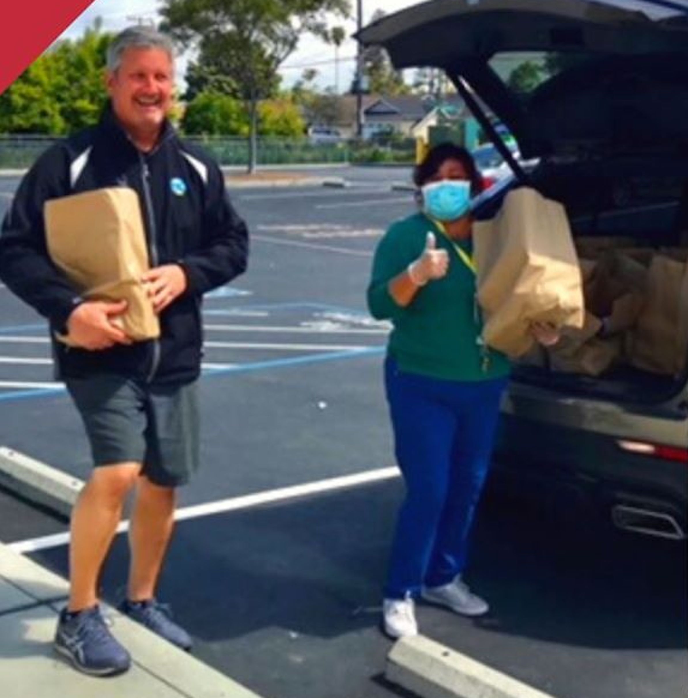 two people holding full grocery bags