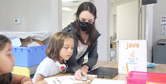 teacher helping child learn java