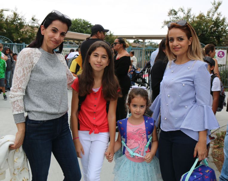 2 moms, 2 daughters smiling at school