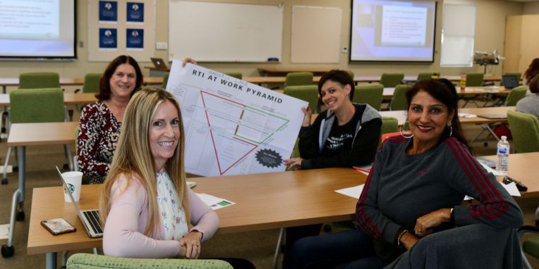 four women holding a poster