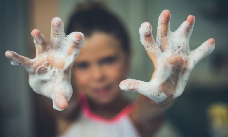 young girl with soapy hands