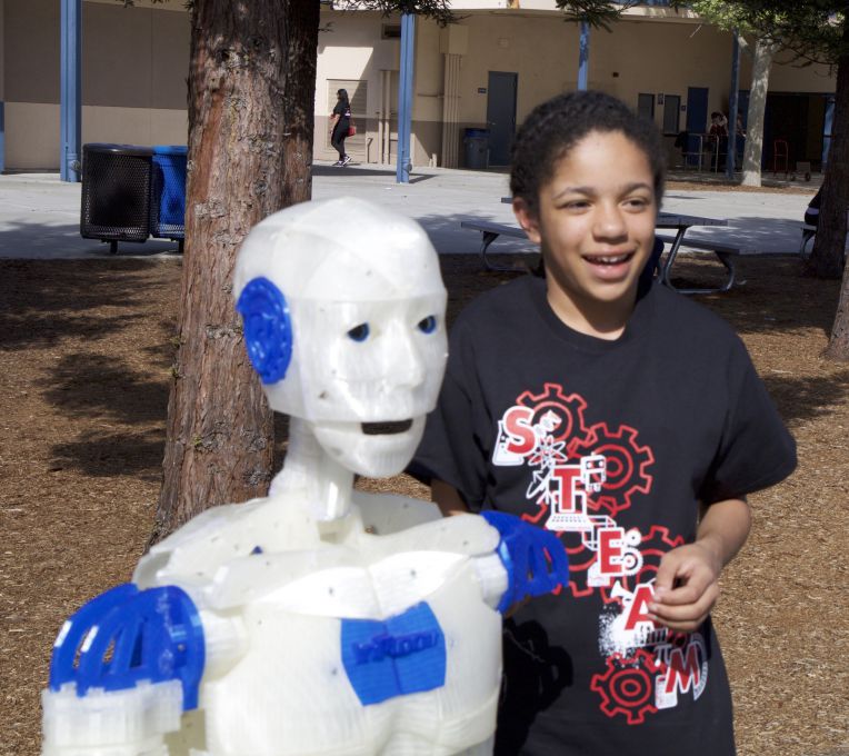 girl stands beside her robot